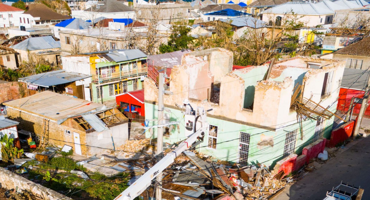Jamaican resident repairing corrugated metal roof after Hurricane Melissa October 2025